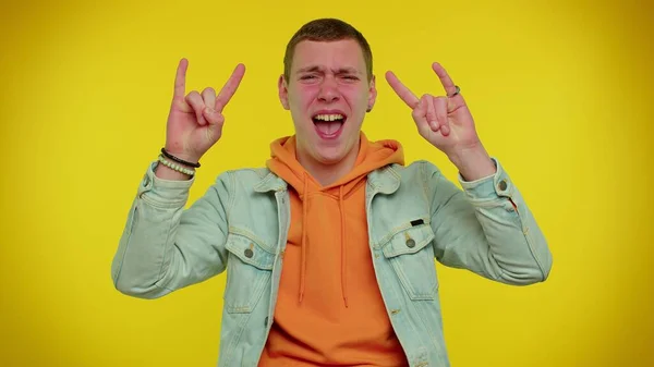 Alegre adolescente hombre mostrando rock n roll gesto por las manos, signo fresco, gritando sí con la cara loca — Foto de Stock