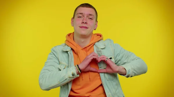 Leende tonåring man gör hjärta gest visar kärlek tecken uttrycker goda känslor och sympati — Stockfoto