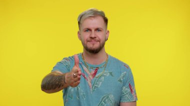 Dost canlısı bir adam kameraya uzanıyor, el sıkışmayı teklif ediyor, nazik bir gülümsemeyle selamlıyor, hoş karşılıyor.