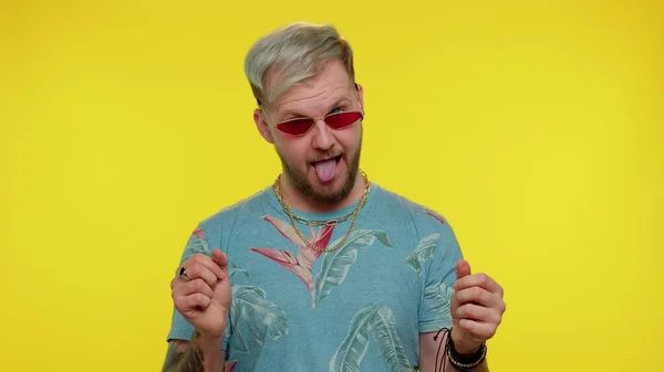 Pazzo uomo in moda t-shirt dimostrando lingua fuori a scherzare, facendo facce stupide, follia — Foto Stock