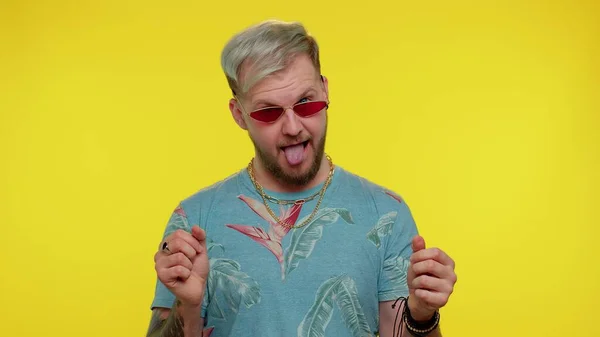 Crazy man in fashion t-shirt demonstrating tongue out fooling around, making silly faces, madness — Stock Photo, Image