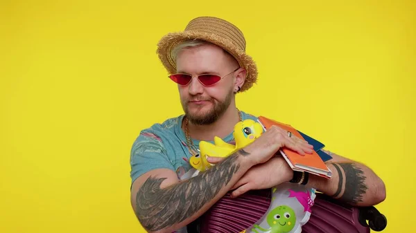 Displeased tired boring traveler tourist bearded stylish man in summer clothes on yellow background