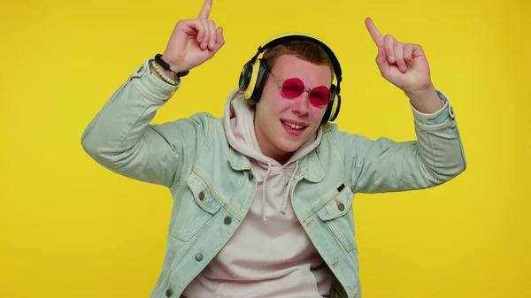 Alegre atraente homem ouvindo música via fones de ouvido e dançando disco brincando se divertindo — Fotografia de Stock