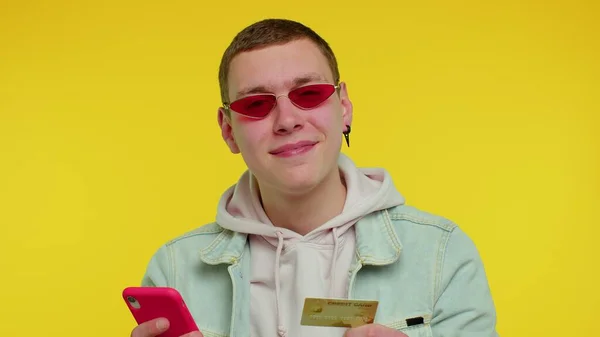 Teen man using credit bank card and smartphone while transferring money, purchases online shopping — Stock Photo, Image