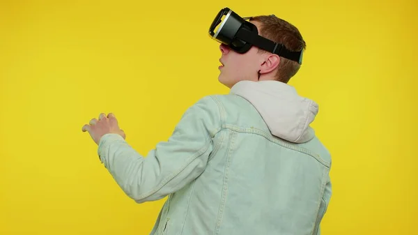 Homem usando tecnologia futurista realidade virtual VR capacete de fone de ouvido para jogar simulação 3D vídeo game — Fotografia de Stock