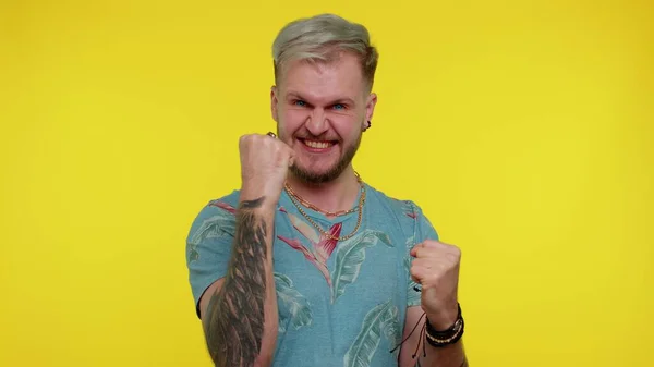 Homem elegante de t-shirt gritando, levantando punhos em gesto Eu fiz isso, celebrando o sucesso, ganhando — Fotografia de Stock