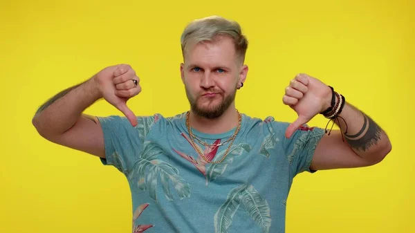 Overstuur man in modieuze t-shirt met duimen naar beneden teken gebaar, afkeuring, ontevreden hekel — Stockfoto