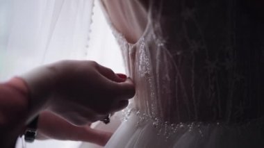 Nedime kravatları ve gelinliği giymeye yardım etmek, gelinin beyaz elbisesiyle sabah hazırlığı.