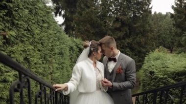Yeni evliler, gelinle beyaz damat parkta merdivenlerde kalın, düğün çifti, aşık erkek ve kadın