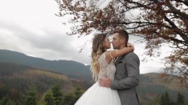 Güzel, genç, yeni evli gelin damadın dağ yamacında kucaklaşması mutlu bir düğün çifti ailesi aşık.