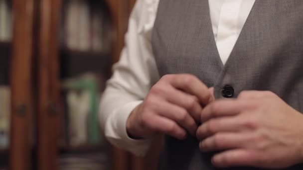 Düğmeli ceket, elleri kapalı, takım elbiseli adam ceketinin düğmelerini bağlıyor ve dışarı çıkmaya hazırlanıyor. — Stok video