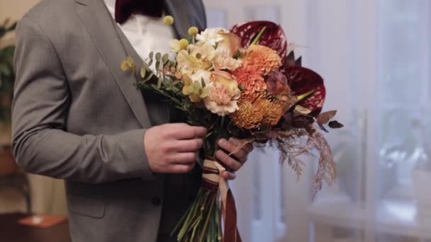 Жених со свадебным букетом в руках дома готовится к поездке к невесте, крупным планом, замедленной съемкой — стоковое видео