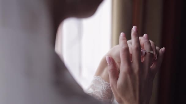 Braut im Nachthemd, Schleier mit Verlobungsring am Fenster. Gesicht aus nächster Nähe lächelnd. Hochzeitsmorgen — Stockvideo