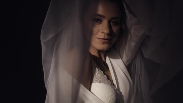 Noiva em vestido boudoir sob véu e em um manto de seda, manhã do casamento, mulher em vestido de noite e véu — Vídeo de Stock