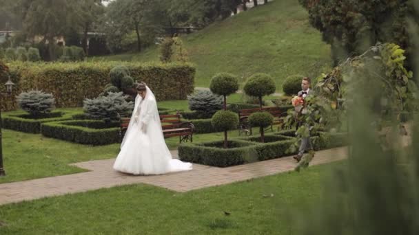 Preciosos recién casados caucásicos novia y novio con ramo en el parque, pareja de boda primera reunión — Vídeos de Stock