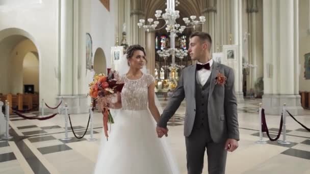 Preciosa familia recién casados pareja novia y novio caminando en una antigua iglesia, ceremonia de boda, matrimonio — Vídeo de stock