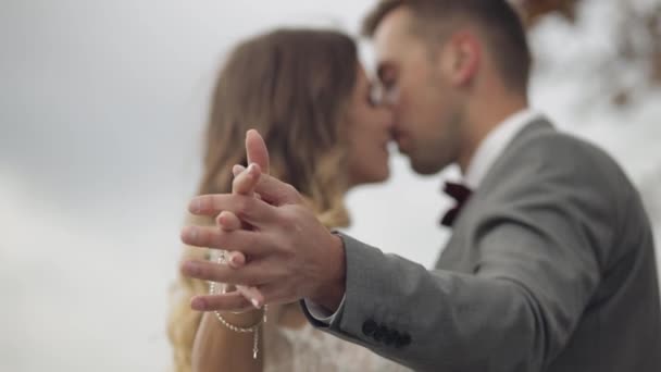 Mooie Kaukasische bruiloft pasgetrouwde familie bruid bruidegom hand in hand, het maken van een kus op de berghelling — Stockvideo