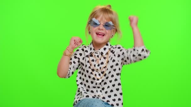 Маленькая блондинка девочка ребенок праздновать победу успеха, радуется делая жест победителя сказать Да, танцы — стоковое видео