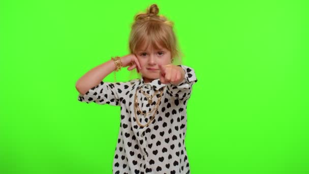 Μικρό χαριτωμένο ξανθό κοριτσάκι κοιτάζοντας κάμερα κάνει τηλεφωνική χειρονομία, όπως λέει hey μου τηλεφωνήσει πίσω — Αρχείο Βίντεο