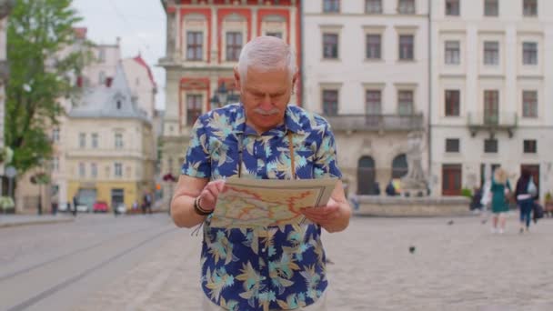 Idosos elegante turista avô homem andando ao longo da rua à procura de maneira usando mapa de papel na cidade — Vídeo de Stock