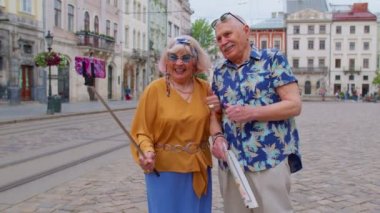 Kıdemli stil sahibi blog yazarı turist kadın selfie çekiyor, cep telefonuyla video görüşmesi yapıyor.
