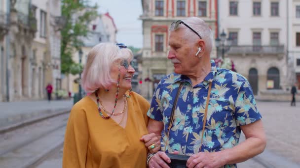 Idős stílusos pár turista férfi és nő élvezi a beszélgetést az utcán Lviv, Ukrajna — Stock videók