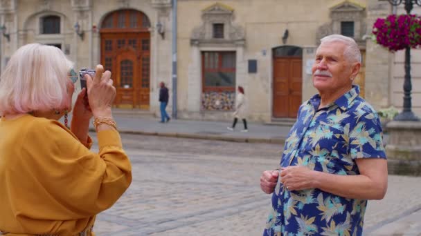 Ηλικιωμένος τουρίστας παππούς λήψη φωτογραφιών της γιαγιάς σε ρετρό κάμερα στην παλιά πόλη του καλοκαιριού — Αρχείο Βίντεο