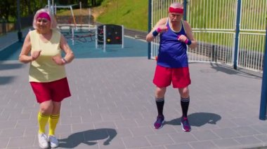 Komik yaşlı erkek kadın sporcular basketbol sahasında egzersiz yapıyorlar.