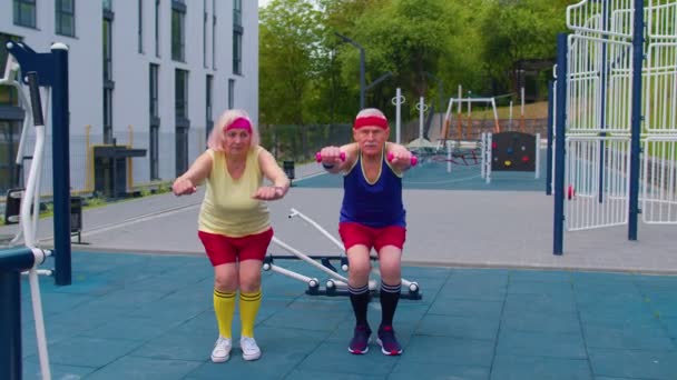 Senior Mann Frau macht aktives Training Stretching Muskeln hocken Fitness-Training auf dem Spielplatz — Stockvideo