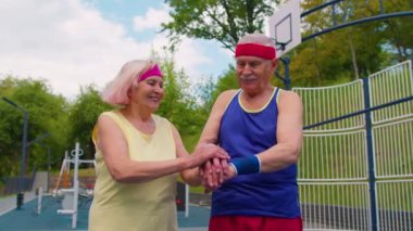 Aktif kıdemli spor takımı atletleri kollarını birleştiriyor, alkışlıyor ve kazanmaya hazır, gülümsüyor.