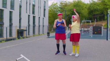 Büyükbaba antrenörü yaşlı nineye halter sporu kardiyo egzersizlerini öğretiyor.