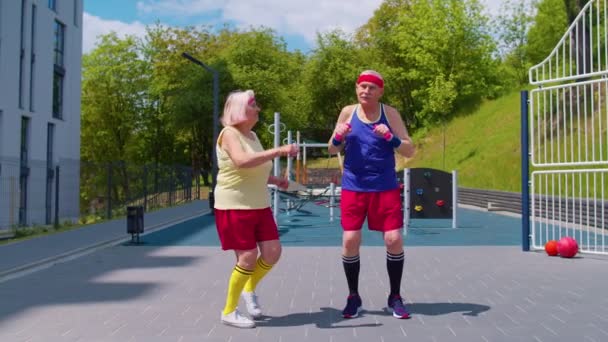 Avô sênior trabalhando no parque infantil fazendo dança esporte alongamento exercício — Vídeo de Stock