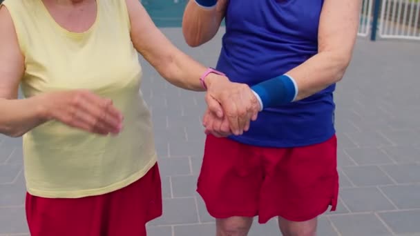 Aktive senioridrettsutøvere som legger armene sammen, jubler og er klare til å vinne, smilende – stockvideo