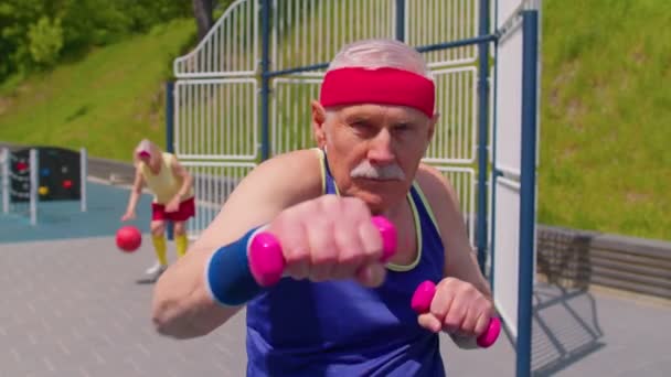 Senior man grootvader doet sport training boksen fitness aerobics cardio-oefeningen met halters — Stockvideo