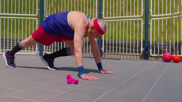 Idoso ativo velho aposentado homem cardio manhã aeróbica rotina push-ups exercício no parque infantil — Vídeo de Stock