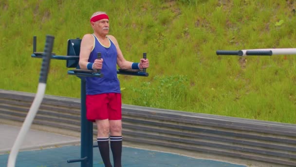ผู้ชายอาวุโสปู่ 80 ปีฝึกกีฬา abs ออกกําลังกายออกกําลังกายคาร์ดิโอในสนามเด็กเล่น — วีดีโอสต็อก