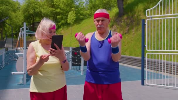 Senior anciana abuela entrenador enseñanza abuelo con deporte levantamiento de pesas ejercicios cardiovasculares — Vídeo de stock