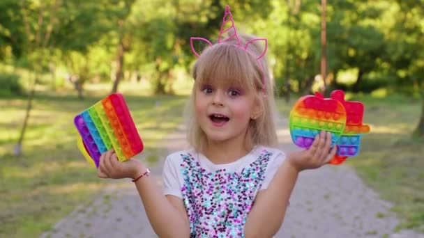 Snygg liten barn unge flicka visar squishy silikon touch skärm bubblor pop det sensoriska spelet leksaker — Stockvideo