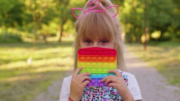 Barn unge leka med pop det sensoriska leksak, flicka pressar på squishy silikon touch screen bubblor — Stockvideo