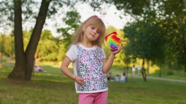 Menina criança segurando muitas bolhas de silicone squishy coloridas pop-lo brinquedos sensoriais populares, polegar para cima — Vídeo de Stock