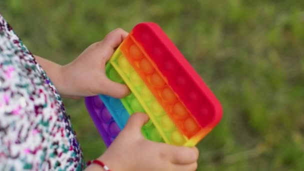 Niña jugando colorido burbujas de silicona blanda juguete sensorial simple hoyuelo pop it juego, primer plano — Vídeos de Stock