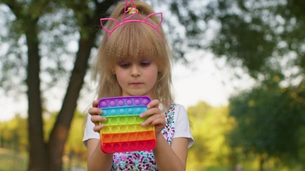 Perempuan gadis anak bermain mendorong pop itu gelembung gelisah stres kecemasan mengurangi memeras mainan permainan sensorik — Stok Video