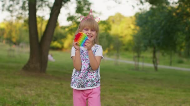 Niños niña apretando prensas colorido anti-estrés pantalla táctil empuje pop es juguete popular en el parque — Vídeos de Stock