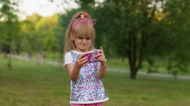 Niño niña pierde en el juego del teléfono móvil, use silicona blanda anti-estrés pop it toy para calmarse — Vídeo de stock