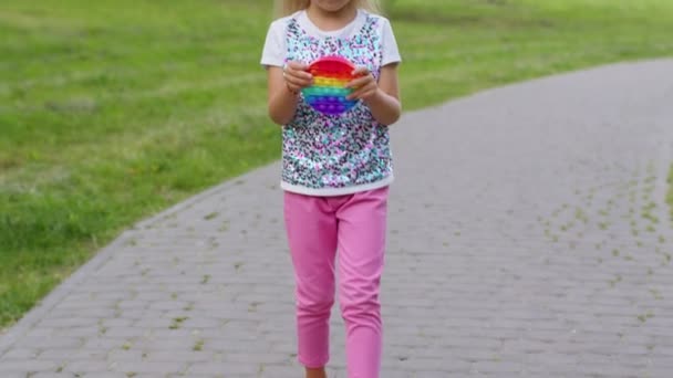 Ребенок девочка играет нажмите лопнуть пузырь скрип игрушки в парке, стресс тревоги облегчения сжатия сенсорной — стоковое видео