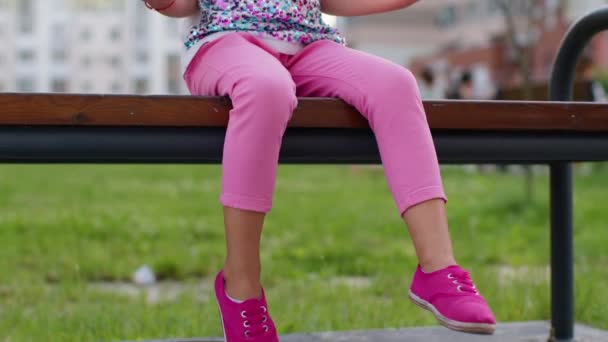 Snygga barn flicka klämma pressar anti-stress push pop det populära leksak på lekplats bänk — Stockvideo
