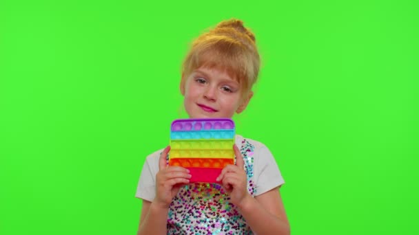 Child kid play with pop it sensory toy, girl presses on squishy silicone touch screen bubbles — Stock Video