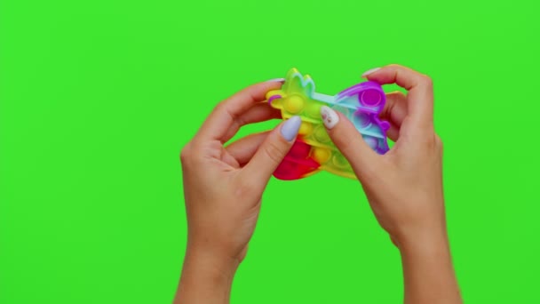女孩的手捏紧按下五彩缤纷的抗压触摸屏，用彩色键把它弹出玩具游戏 — 图库视频影像