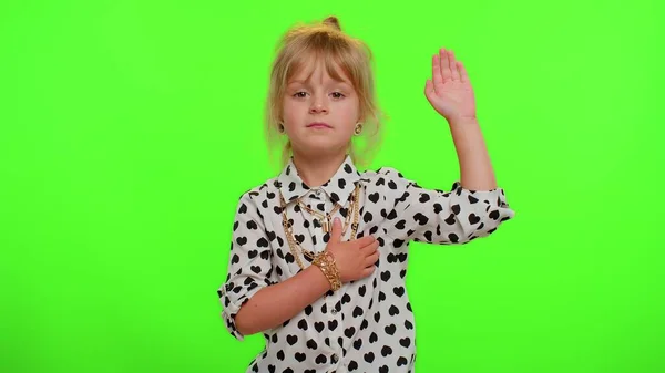 Dziecko przysięga, że będzie szczere, podnosząc rękę do przysięgi, obiecując mówić prawdę trzymając rękę na klatce piersiowej. — Zdjęcie stockowe