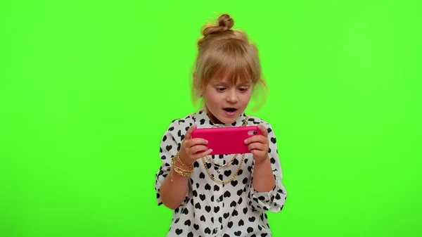 Беспокойная веселая зависимая девочка с энтузиазмом играет в привод гоночных видеоигр на мобильном телефоне — стоковое фото